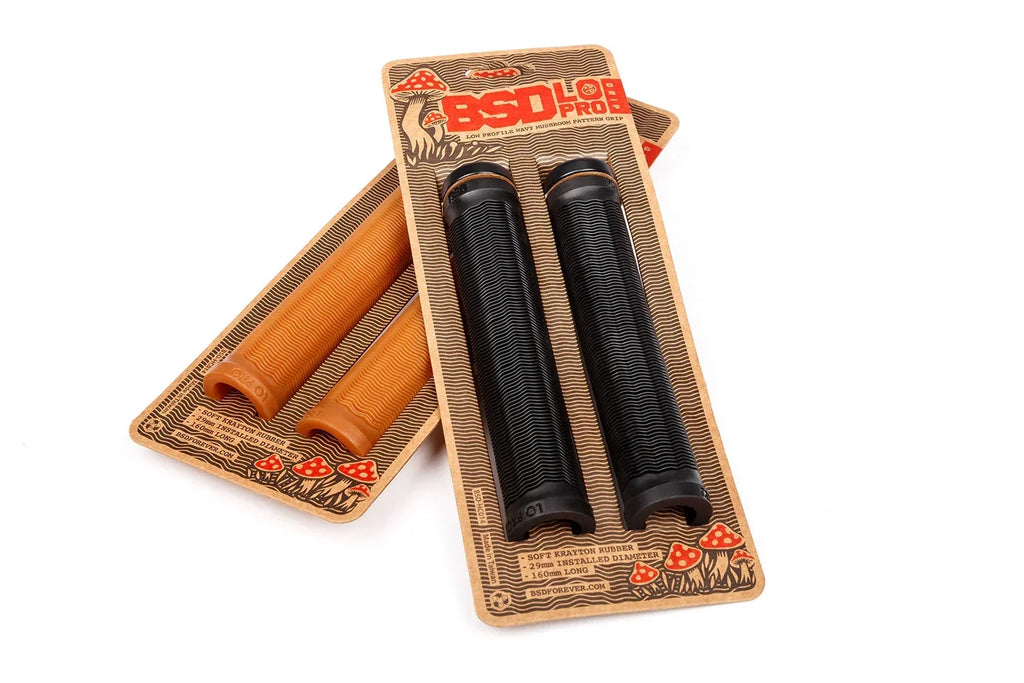 Poignées de guidon BMX BSD Pro en caoutchouc, coloris noir et orange, sur emballages.