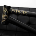 Close-up of matte black BMX frame with gold Fiend logo detailing.