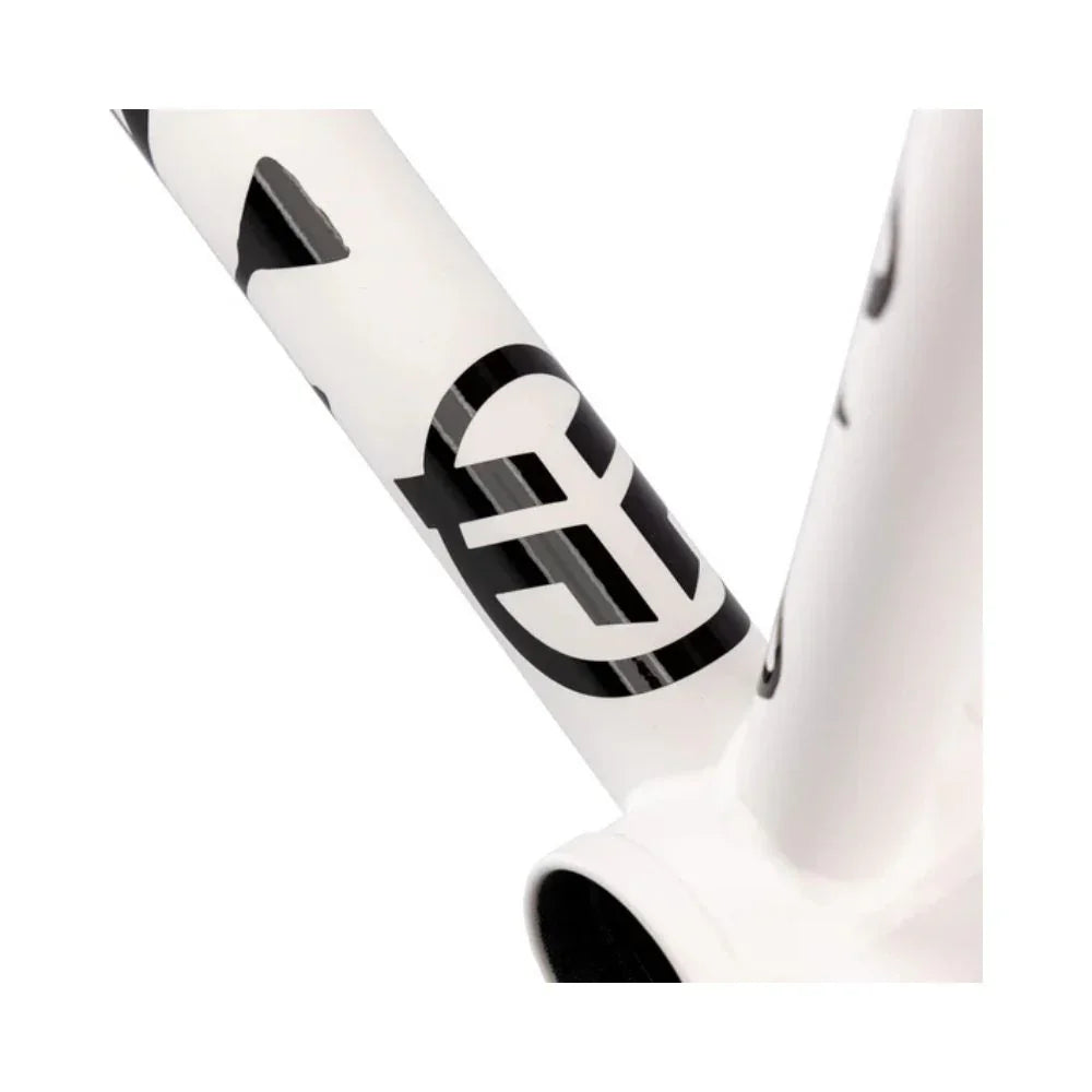 Close-up of a matte white BMX bike frame with black graphics and geometric logo.