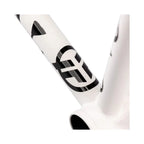 Close-up of a matte white BMX bike frame with black graphics and geometric logo.