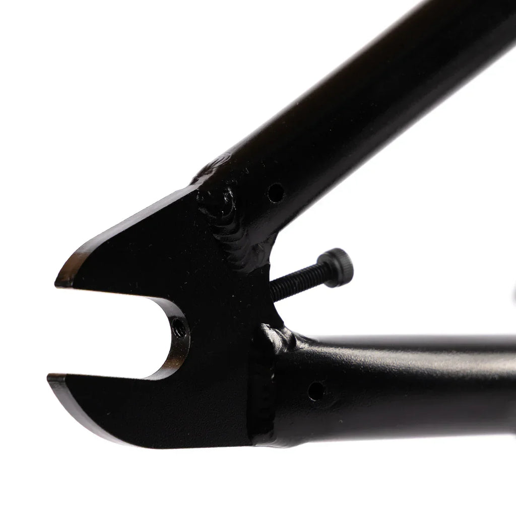 Close-up of black BMX frame dropout and chain tensioner bolt, showing welding detail