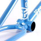 Close-up of a blue BMX bike frame with white graphics and smooth welds