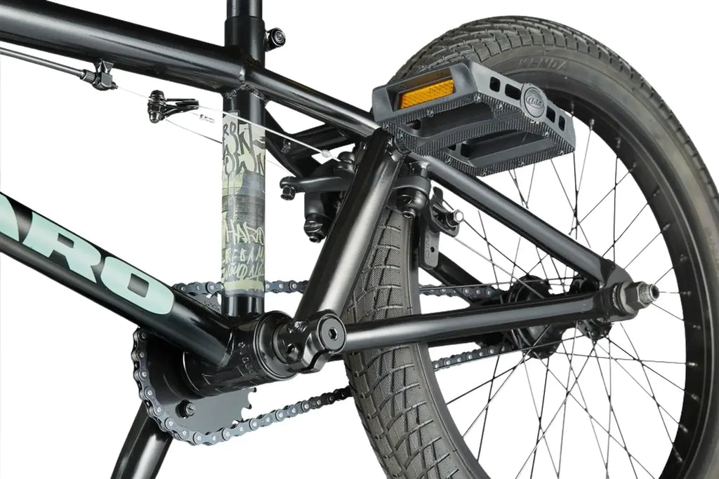 Détail du cadre noir et de la transmission d'un vélo BMX avec pédales plates