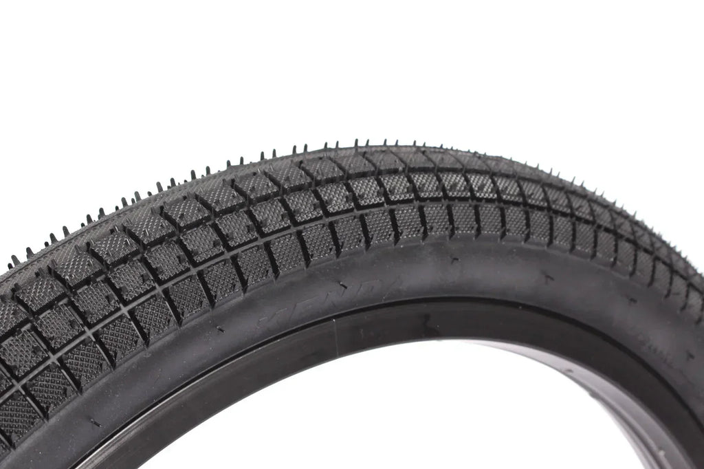 Pneu BMX noir avec crampons et motif en losange pour traction optimale sur tout terrain