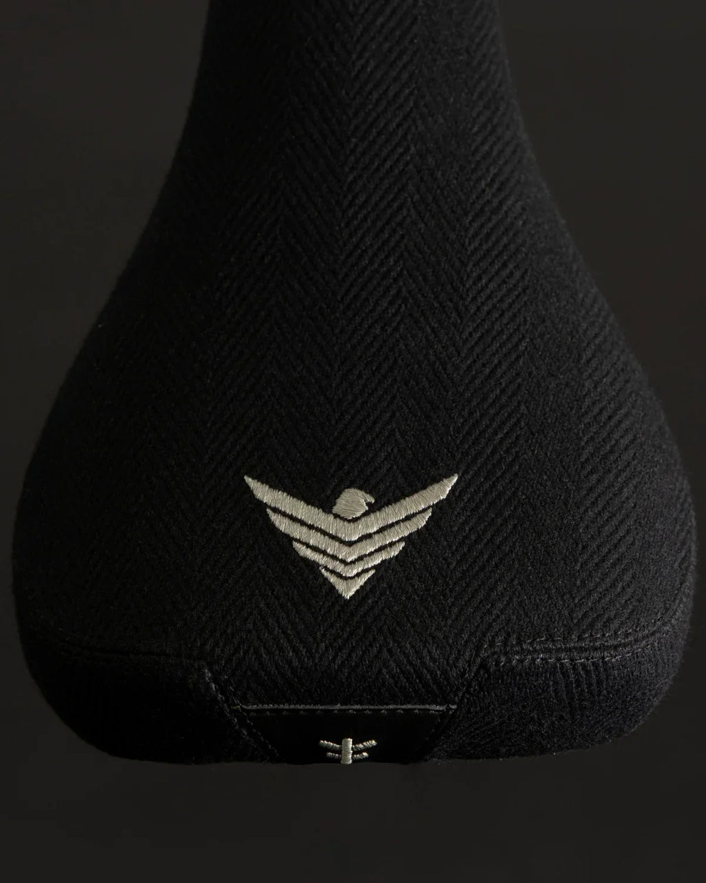 Selle BMX noire texturée avec logo brodé aigle, design robuste pour vélo freestyle