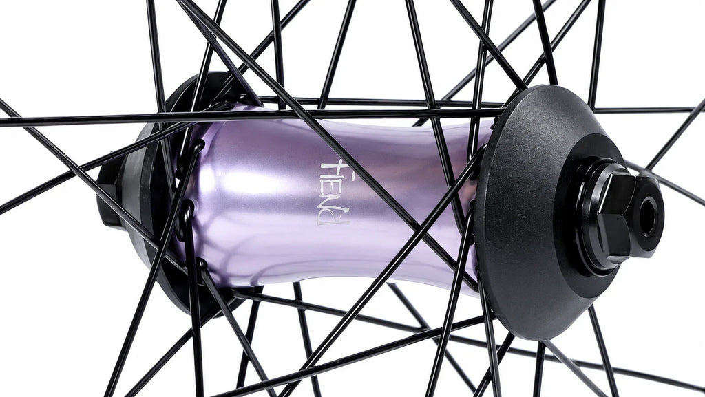 Roue BMX avec moyeu violet métallique et rayons noirs, design robuste pour freestyle