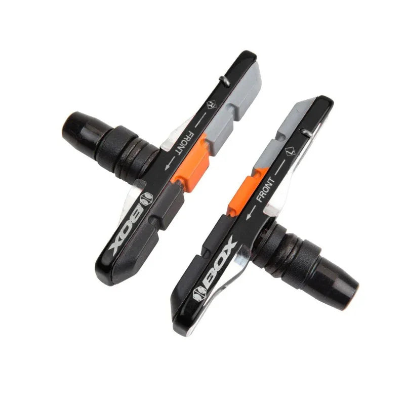 Plaquettes de frein BMX noires avec détails orange, marquées 'FRONT' et 'BOX'