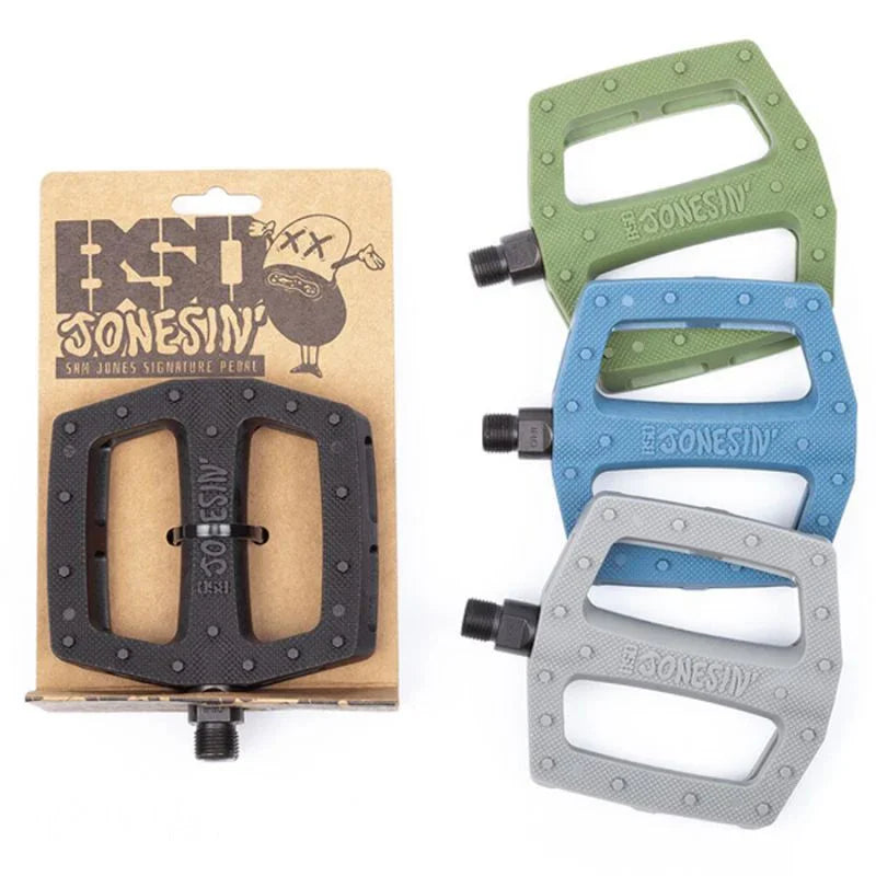 Pedales BMX Jonesin' en noir, vert, bleu et gris, avec emballage signature Sam Jones