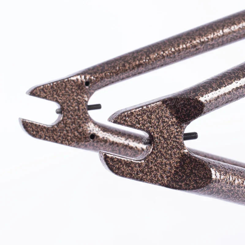 Fourche BMX en métal texturé avec finition bronze, détails de montage visibles