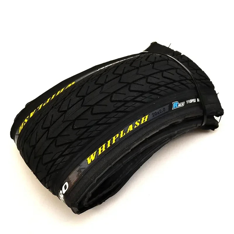 Folded BMX bike tire with tread pattern and WHIPLASH branding on the sidewall