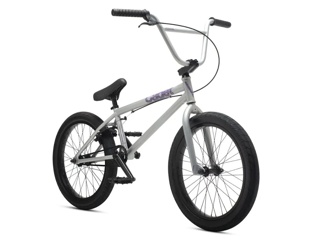Vélo BMX gris avec détails violets, cadre robuste et pneus larges pour tricks et freestyle