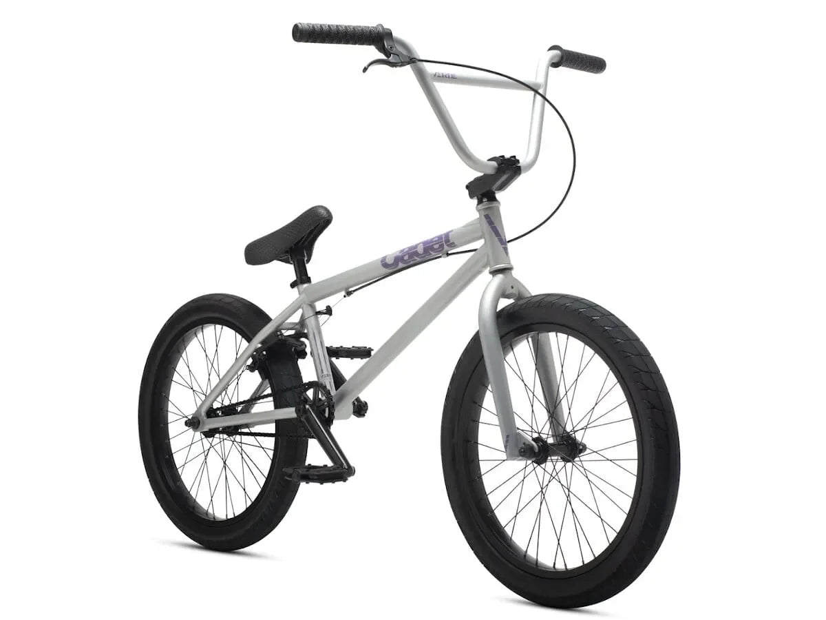 Vélo BMX gris avec détails violets, cadre robuste et pneus larges pour tricks et freestyle