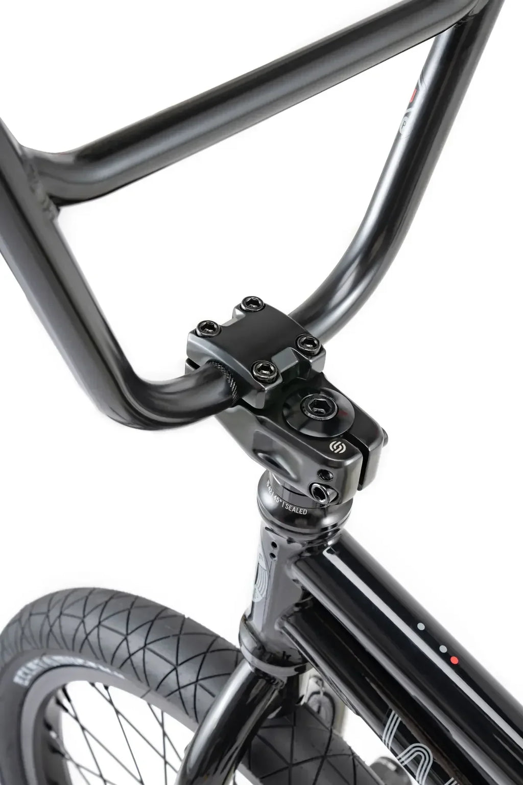 Détail d'un vélo BMX noir avec guidon et fourche robustes, pneu à crampons pour freestyle
