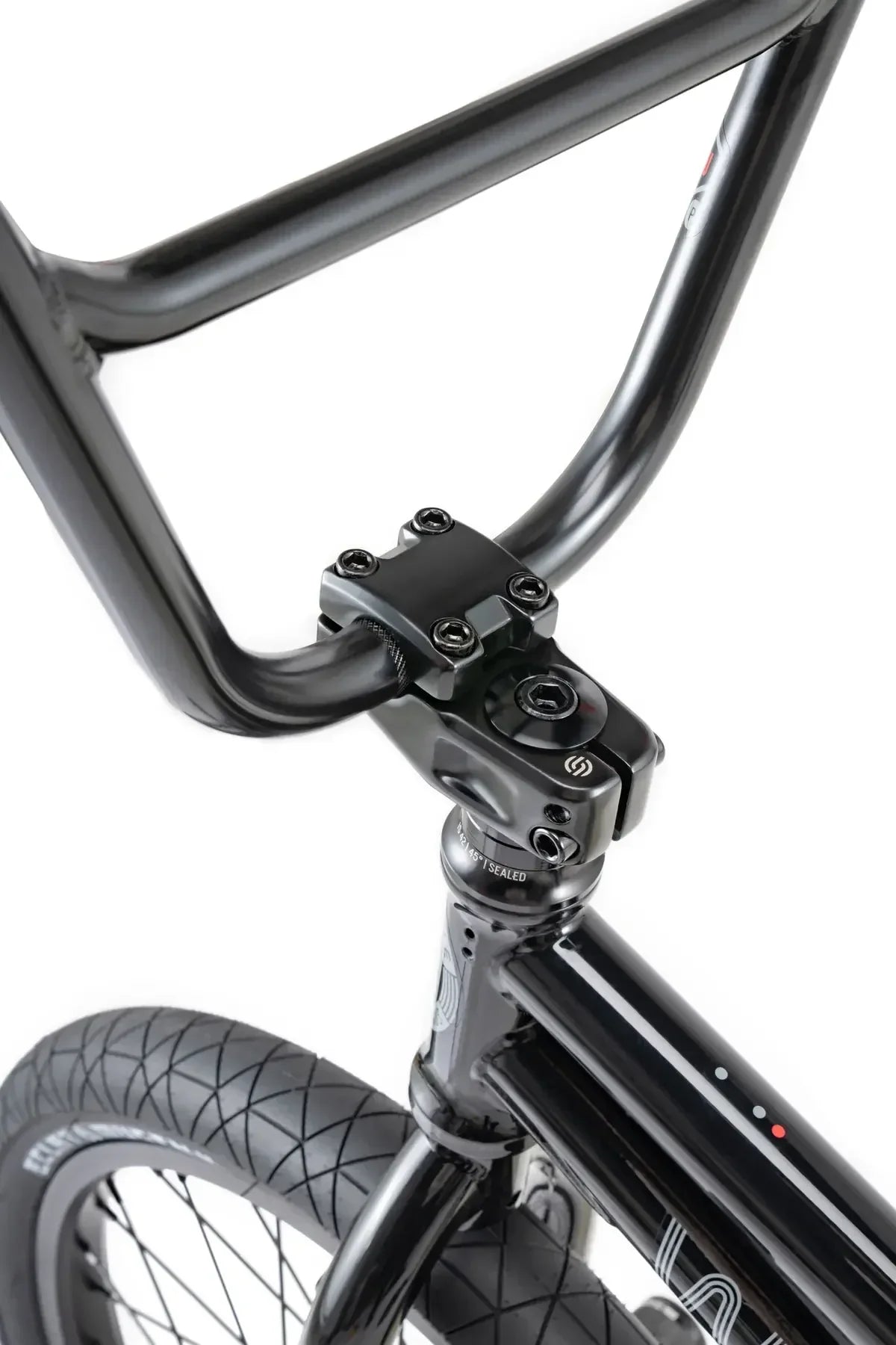 Détail d'un vélo BMX noir avec guidon et fourche robustes, pneu à crampons pour freestyle