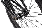 Détail roue BMX noire avec moyeu et chaîne, cadre robuste pour freestyle